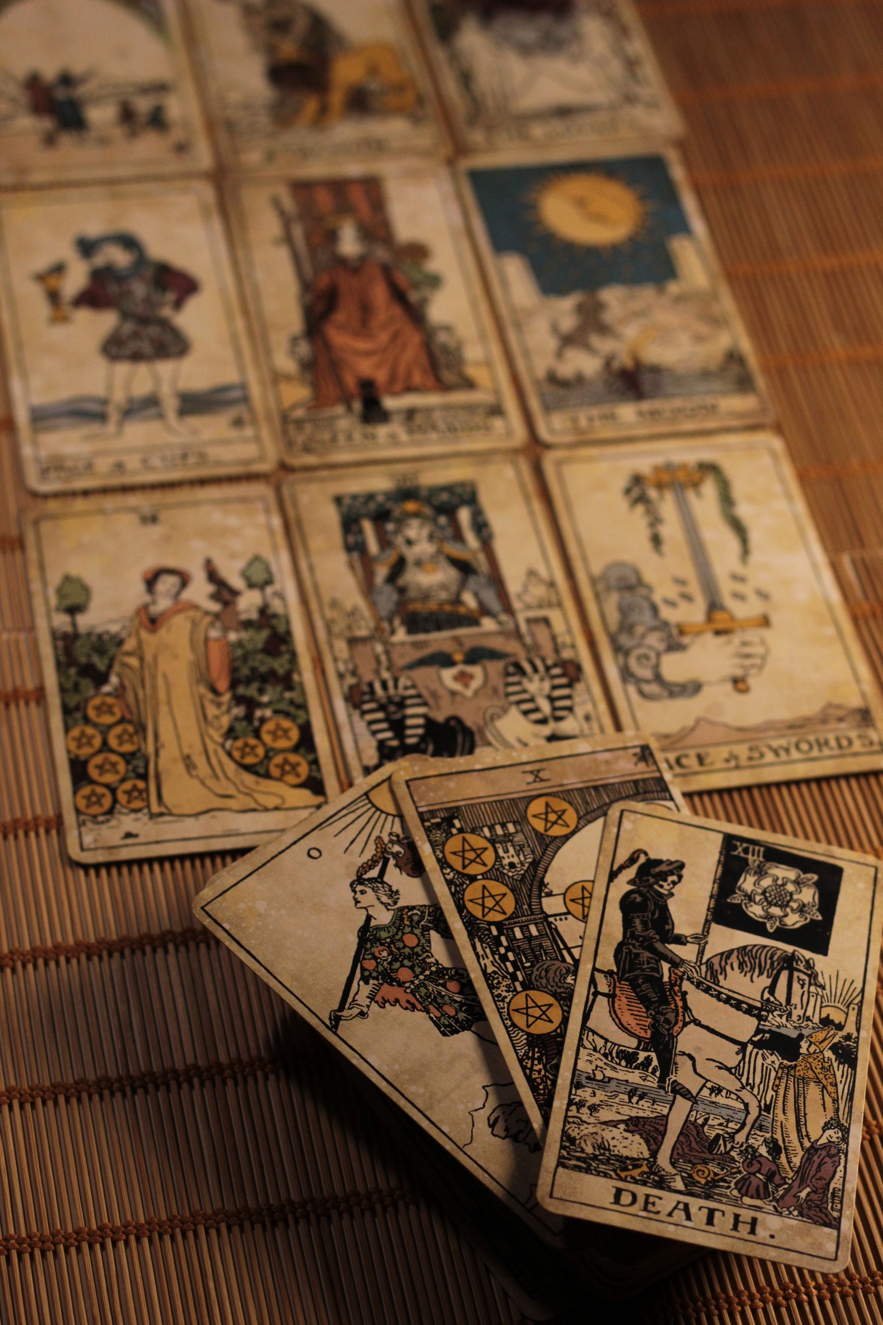 A spread of vintage tarot cards fanned across a woven mat